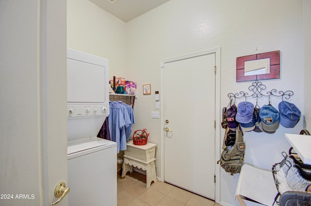 washroom with stacked washer and dryer and light tile patterned floors