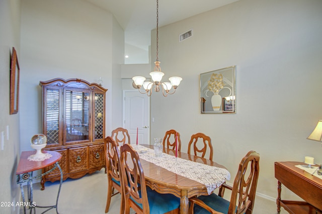 carpeted dining area featuring a chandelier and high vaulted ceiling