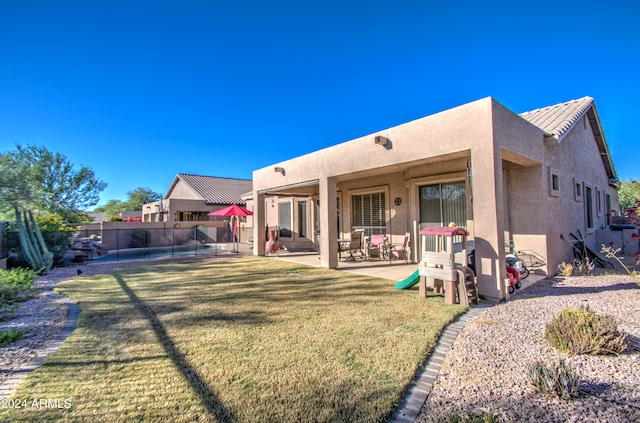 rear view of house with a patio and a yard