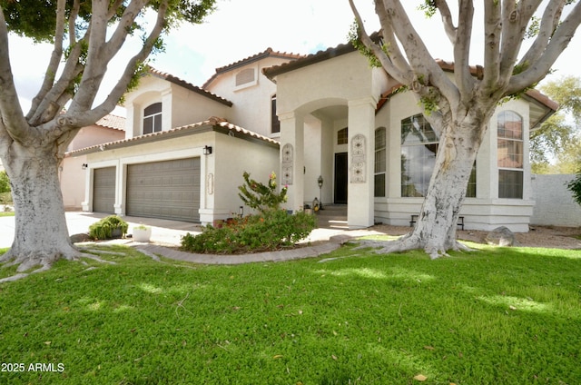 mediterranean / spanish-style home with a garage, stucco siding, a tiled roof, and a front lawn