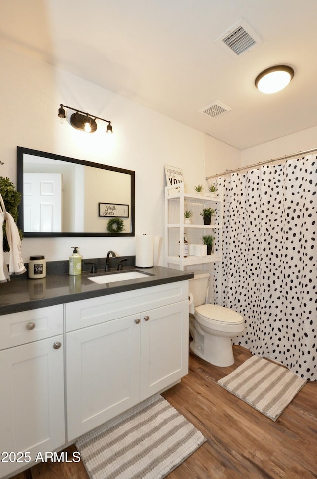 full bath featuring visible vents, toilet, wood finished floors, and vanity