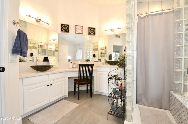 full bath with curtained shower, vanity, and visible vents