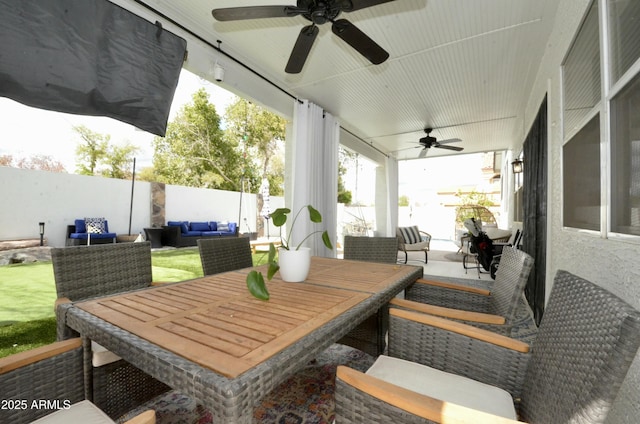 view of patio / terrace featuring outdoor dining space, ceiling fan, an outdoor hangout area, and a fenced backyard