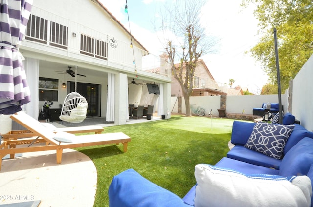 view of yard with a patio, a balcony, a ceiling fan, an outdoor living space, and a fenced backyard