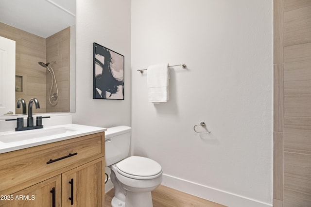 bathroom featuring vanity, hardwood / wood-style flooring, toilet, and a tile shower