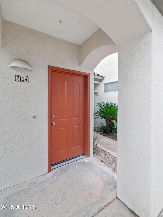 doorway to property featuring stucco siding