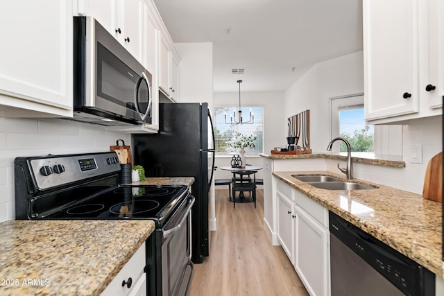 kitchen featuring stainless steel appliances, white cabinetry, a sink, and decorative light fixtures