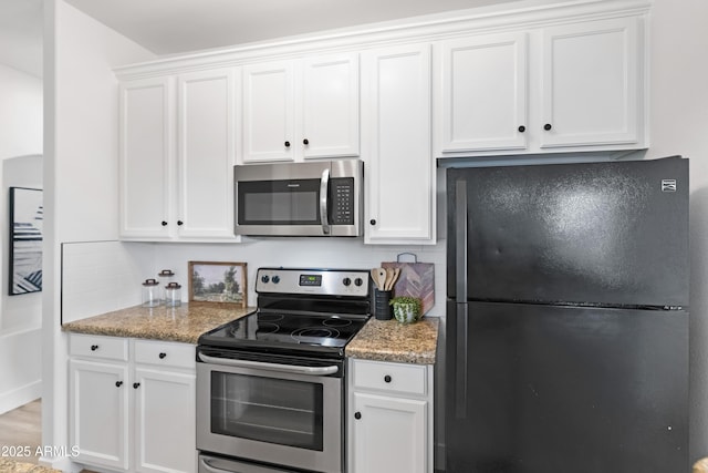 kitchen with white cabinetry, tasteful backsplash, light hardwood / wood-style flooring, appliances with stainless steel finishes, and dark stone counters