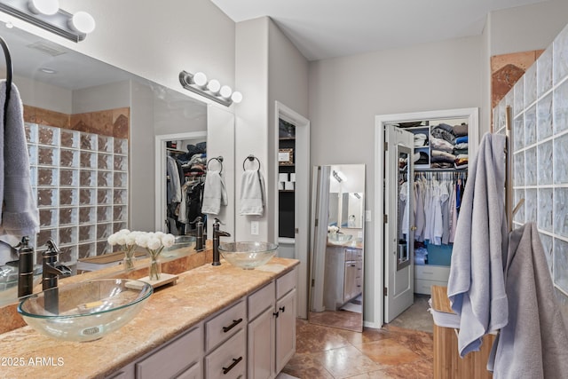 16404 S 18th Dr, Phoenix, AZ 85045 - bathroom with double vanity, a walk in shower, a spacious closet, and tile patterned flooring