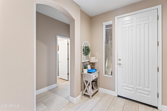 16404 S 18th Dr, Phoenix, AZ 85045 - foyer entrance with arched walkways, light wood-style floors, and baseboards
