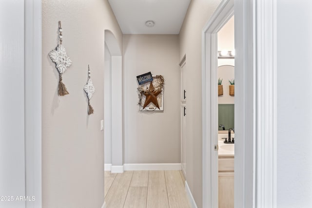 16404 S 18th Dr, Phoenix, AZ 85045 - corridor featuring baseboards, a sink, and light wood finished floors