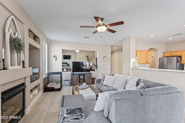 16404 S 18th Dr, Phoenix, AZ 85045 - living area featuring a ceiling fan, light wood finished floors, a glass covered fireplace, and recessed lighting