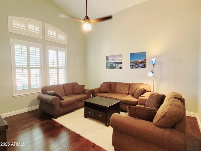 living area featuring a ceiling fan, baseboards, dark wood-style floors, and lofted ceiling