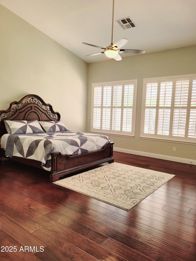 bedroom with baseboards, a ceiling fan, dark wood finished floors, and visible vents