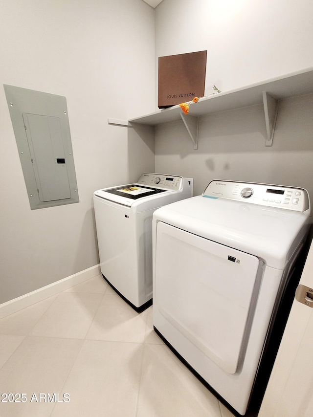 laundry area with electric panel, laundry area, baseboards, light tile patterned flooring, and washer and clothes dryer
