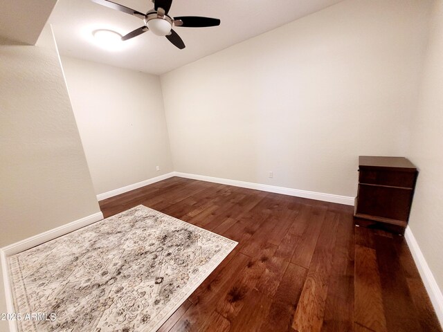 unfurnished room with dark wood-type flooring, baseboards, and ceiling fan