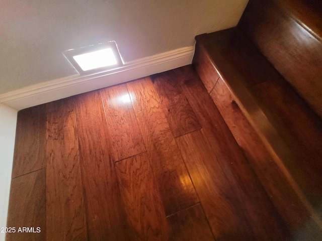 interior details with baseboards and wood finished floors