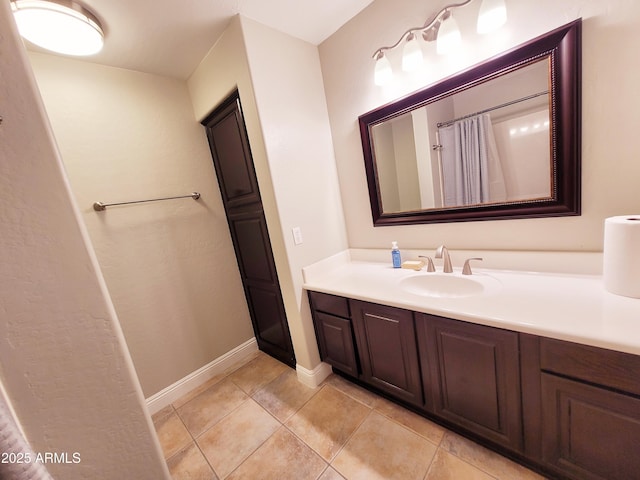 full bath with tile patterned flooring, baseboards, and vanity