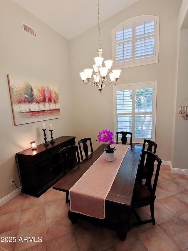 dining room featuring light tile patterned flooring, high vaulted ceiling, a chandelier, baseboards, and visible vents