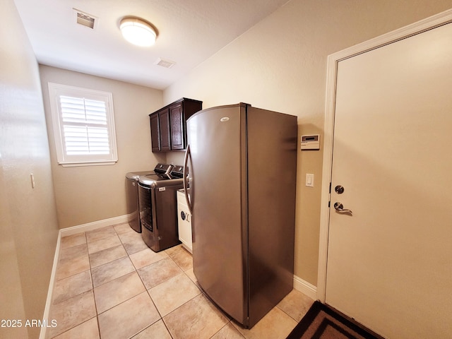 kitchen with visible vents, freestanding refrigerator, dark brown cabinets, baseboards, and washer and clothes dryer