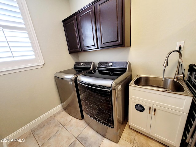 laundry room with washing machine and clothes dryer, cabinet space, a sink, light tile patterned floors, and baseboards