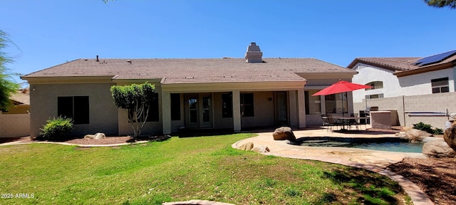 rear view of house featuring a patio, fence, a yard, and a tile roof