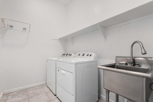 washroom with washing machine and clothes dryer, sink, and light tile patterned floors