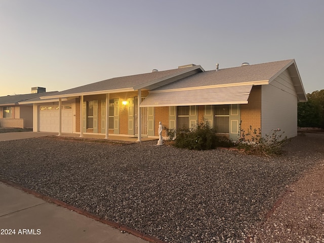 ranch-style house with a porch and a garage