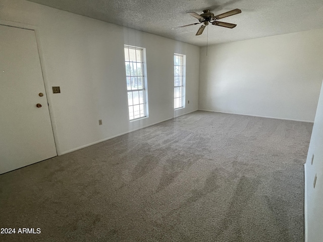 spare room with carpet, ceiling fan, and a textured ceiling