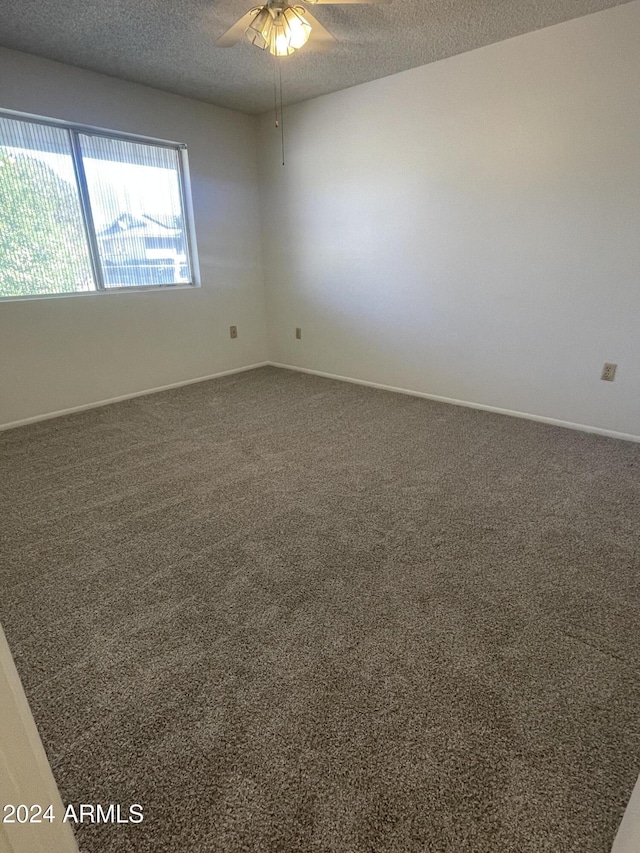 carpeted spare room with a textured ceiling and ceiling fan