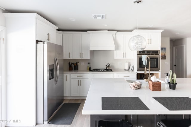 8132 E Valley View Rd, Scottsdale, AZ 85250 - kitchen featuring light wood finished floors, stainless steel appliances, light countertops, visible vents, and custom exhaust hood