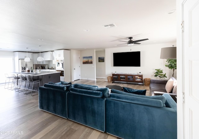 8132 E Valley View Rd, Scottsdale, AZ 85250 - living room with ceiling fan, baseboards, visible vents, and light wood-type flooring