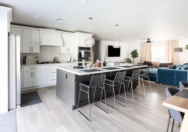 8132 E Valley View Rd, Scottsdale, AZ 85250 - kitchen with premium range hood, visible vents, a kitchen breakfast bar, and stainless steel appliances