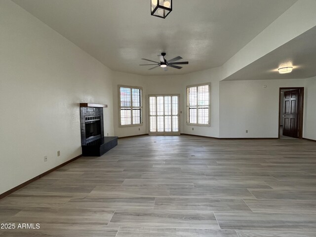 2169 E Bishop Dr, Tempe, AZ 85282 - unfurnished living room with ceiling fan, plenty of natural light, a tile fireplace, and baseboards
