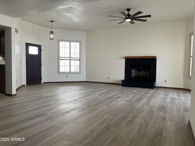 2169 E Bishop Dr, Tempe, AZ 85282 - unfurnished living room with a ceiling fan, wood finished floors, baseboards, and a fireplace with raised hearth