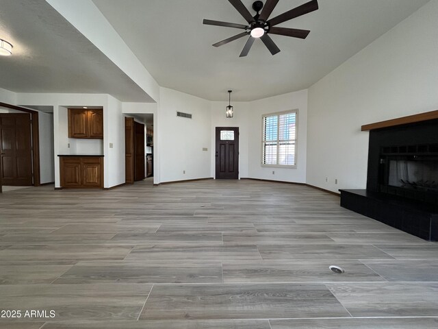 2169 E Bishop Dr, Tempe, AZ 85282 - unfurnished living room featuring a ceiling fan, a fireplace with raised hearth, baseboards, and light wood finished floors