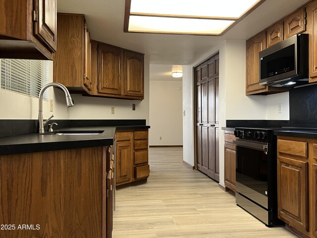 2169 E Bishop Dr, Tempe, AZ 85282 - kitchen with stainless steel microwave, black gas range, a sink, and dark countertops