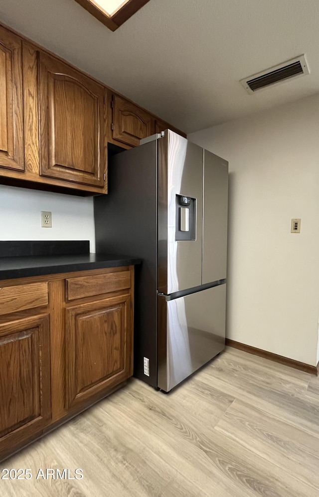 2169 E Bishop Dr, Tempe, AZ 85282 - kitchen featuring stainless steel fridge with ice dispenser, light wood-style floors, dark countertops, and brown cabinetry