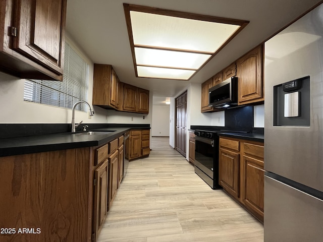 2169 E Bishop Dr, Tempe, AZ 85282 - kitchen featuring stainless steel appliances, a sink, dark countertops, and light wood-type flooring