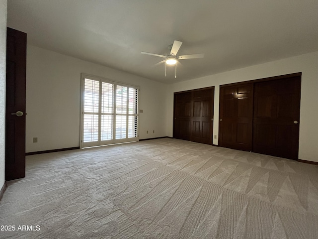 2169 E Bishop Dr, Tempe, AZ 85282 - unfurnished bedroom featuring light carpet, baseboards, two closets, and ceiling fan