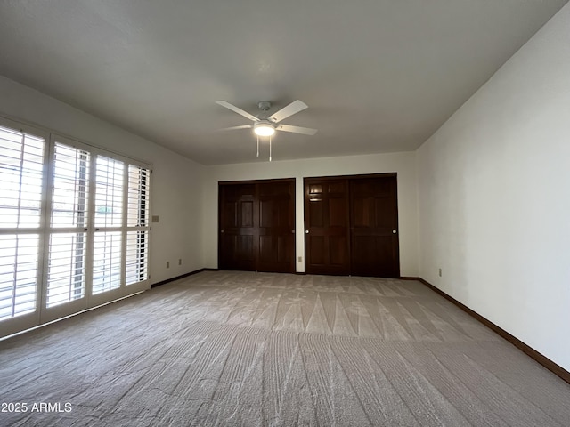 2169 E Bishop Dr, Tempe, AZ 85282 - unfurnished bedroom with light colored carpet, two closets, baseboards, and a ceiling fan
