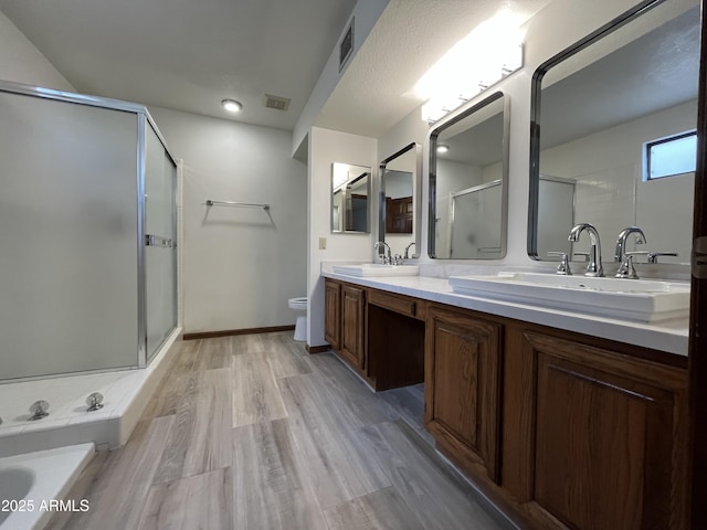 2169 E Bishop Dr, Tempe, AZ 85282 - full bathroom featuring a shower stall, double vanity, toilet, wood finished floors, and a bathtub