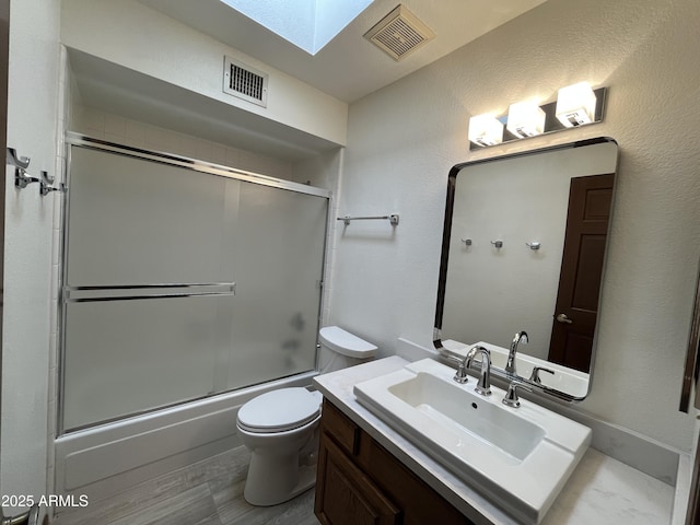 2169 E Bishop Dr, Tempe, AZ 85282 - full bathroom with a skylight, vanity, toilet, and bath / shower combo with glass door