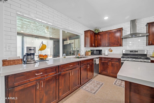 kitchen featuring appliances with stainless steel finishes, sink, light tile patterned flooring, wall chimney exhaust hood, and decorative backsplash