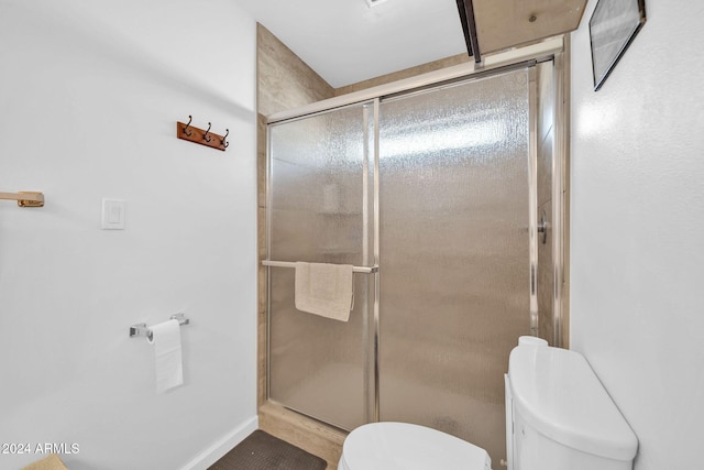 bathroom with toilet and an enclosed shower