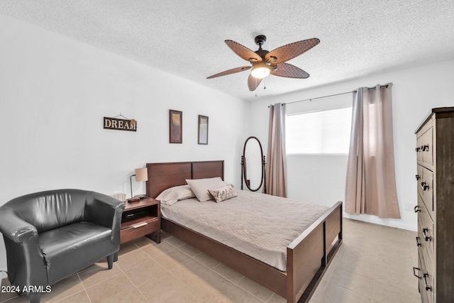 bedroom with a textured ceiling, light tile patterned floors, and ceiling fan