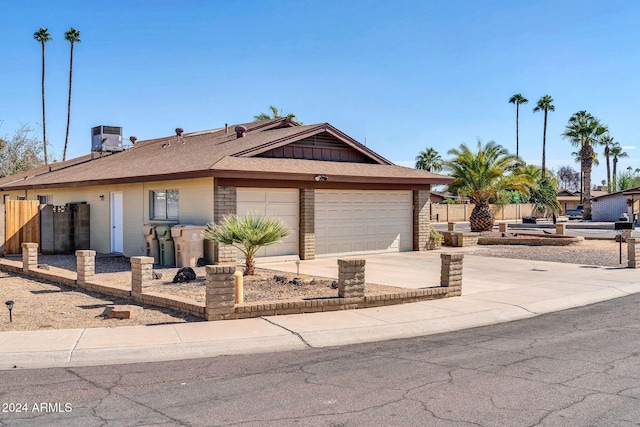 single story home with central AC unit and a garage