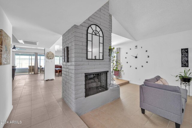 tiled living room featuring lofted ceiling, a textured ceiling, a fireplace, and ceiling fan