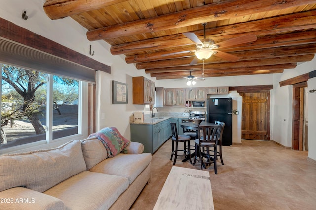 interior space featuring sink, wooden ceiling, ceiling fan, beam ceiling, and black appliances