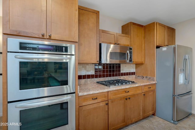 kitchen with tasteful backsplash, appliances with stainless steel finishes, and light tile patterned floors